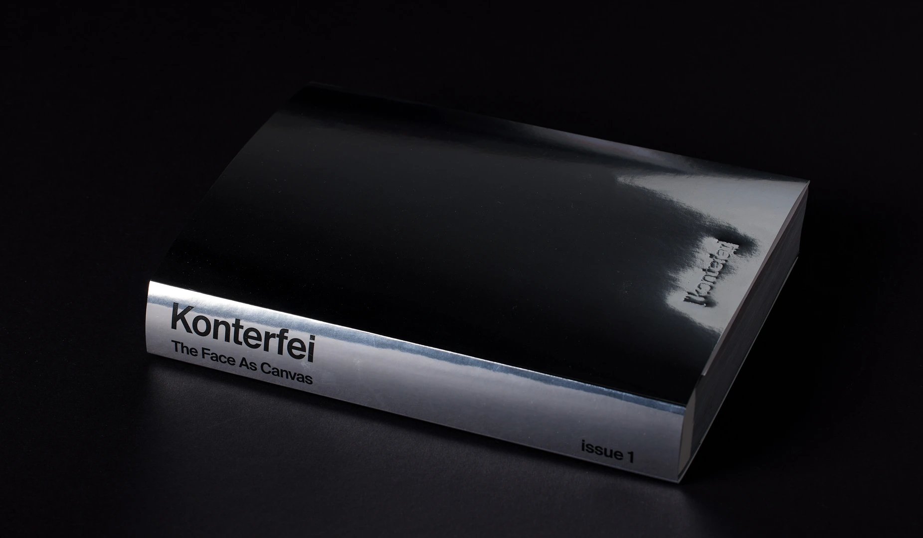Konterfei Issue 01 cover — chrome spine on black
