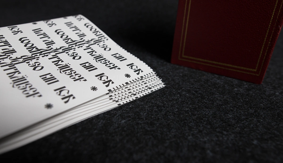 Stack of booklets next to the closed red slipcase, showing the gold-tooled border.